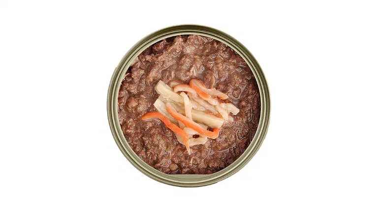 Hộp pate mở nắp với phần thịt nâu và vài sợi cá, cà rốt trang trí ở giữa