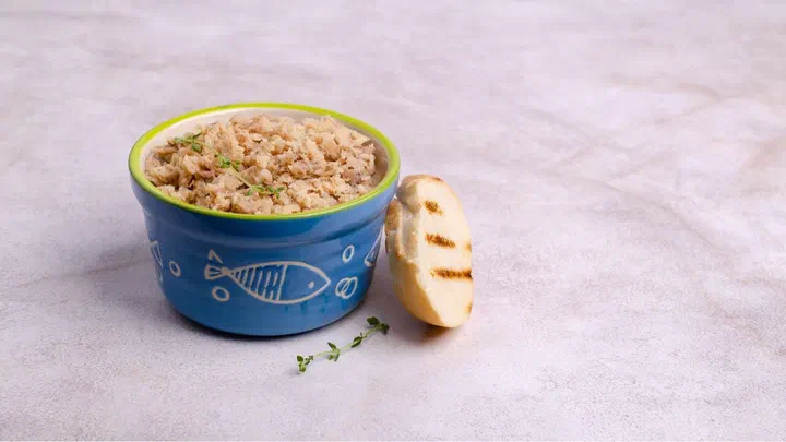 Bát sứ xanh hoạ tiết cá đựng pate cá xay bên cạnh một lát bánh mì nướng