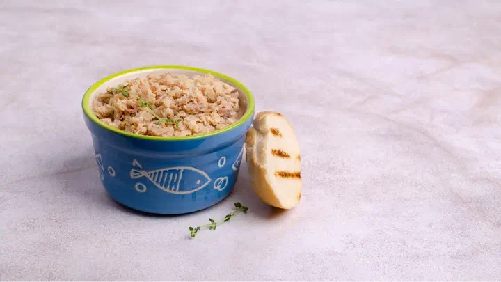 Bát sứ xanh hoạ tiết cá đựng pate cá xay bên cạnh một lát bánh mì nướng