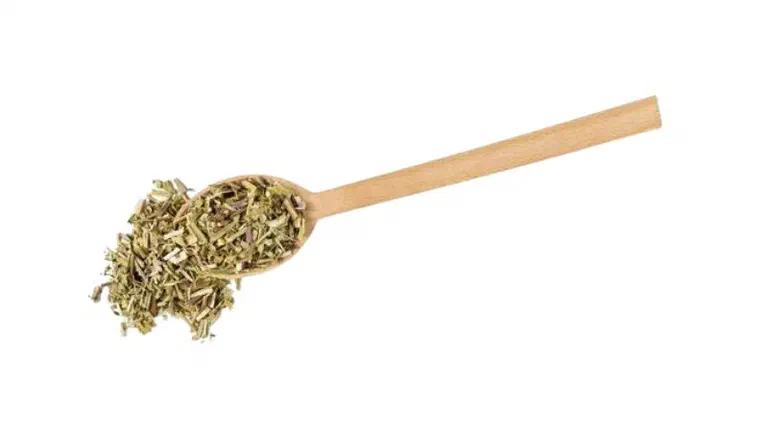Thìa gỗ đựng cỏ bạc hà mèo catnip khô đã cắt nhỏ trên nền trắng